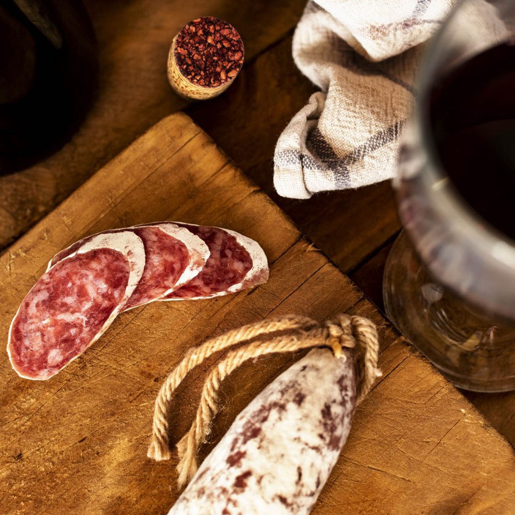 Salami and red wine on a wooden board